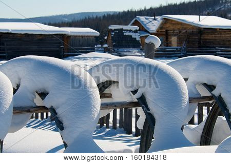 Covered with snow fence in village on sunset