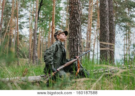 Woman hunter with a gun. Hunting in the woods.