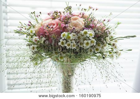 Small pink rustical flower bouquet made of roses and field flowers