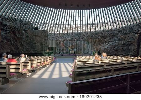Helsinki, Finland - April 10, 2010: People sit on the benches in Temppeliaukio Church (Church of the Rock) on Lutherinkatu. Was built directly into solid rock and opened in 1969