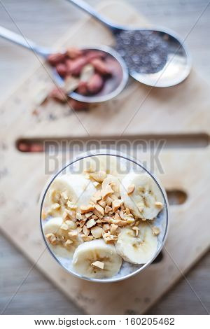 Banana chia yogurt pudding decorated with ripe sliced banana and peanuts