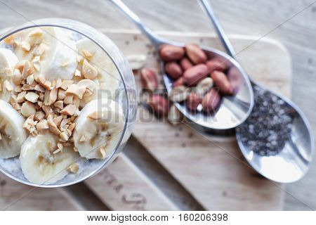 Banana chia yogurt pudding decorated with ripe sliced banana and peanuts