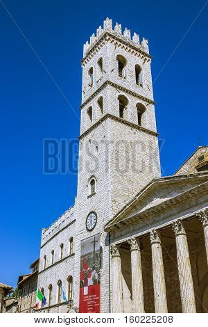 ASSISI ITALY - SEPTEMBER 4 2016: Palace of the People's Captain (Capitano del Popolo) Town Hall tower and the temple of Minerva on the Municipality Square (Piazza del Comune) in the old town of Assisi region of Umbria Italy