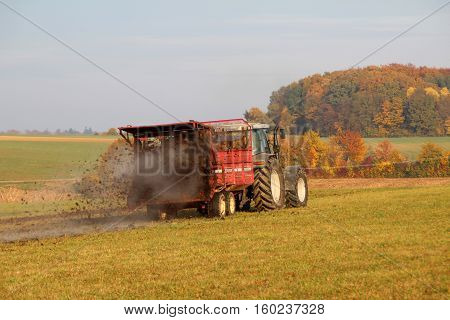 Tractor at work. Tractor spread manure .
