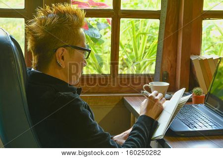 Woman notes something on in the note book.