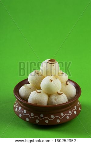 Indian Sweet or Dessert - Rasgulla, Famous Bengali sweet in clay bowl on green background
