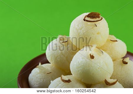 Indian Sweet or Dessert - Rasgulla, Famous Bengali sweet in clay bowl on green background