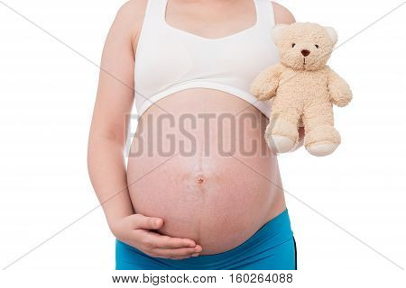 The belly asia pregnant woman holdind a teddy bear doll isolate on white background