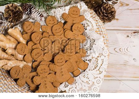Christmas smiling gingerbread men men and women on white handmade lace with Christmas decoration