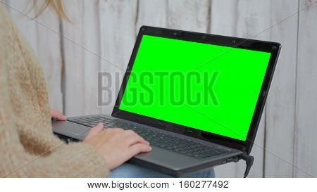 Woman using laptop with green screen. Business, communication, freelance and internet concept