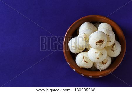 Indian Sweet or Dessert - Rasgulla, Famous Bengali sweet in clay bowl on blue background