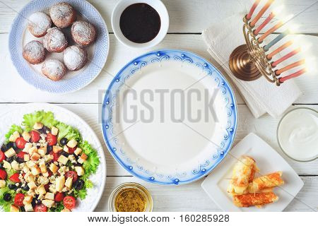Traditional Hanukkah dishes on the white wooden table top view
