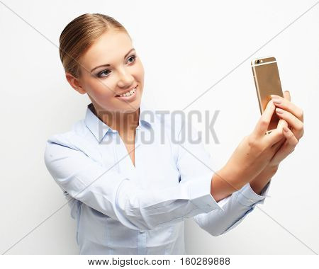 lifestyle, tehnology  and people concept: Beautiful young woman is making selfie photo with smartphone.