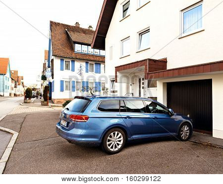 FREUDENSTADT GERMANY - NOV 20 2016: Modern Hybrid Volkswagen Passat wagon car parked on the German street with german architecture in the background