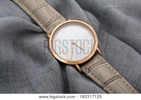 Gray band wrist watch on gray silk fabric background