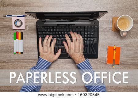 Male hand typing on laptop, message PAPERLESS OFFICE
