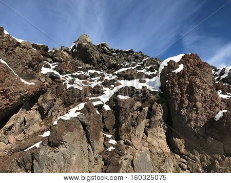 A fresh coat of snow on jagged lava rocks in Central Oregon on a sunny winter morning.