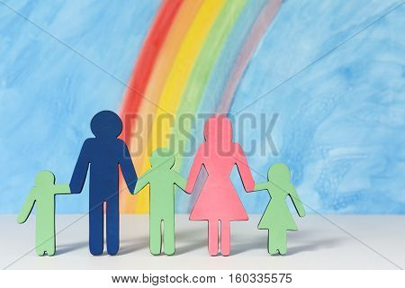 Father mother and children icons with a rainbow and blue sky to illustrate the concept of the traditional family unit in portrait format.