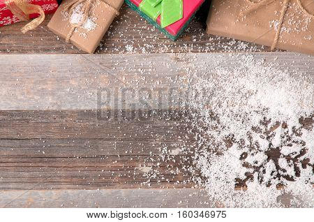 Christmas decoration and gift boxes. Snowflake on wooden background