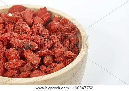 goji berry in wooden cup on white background.
