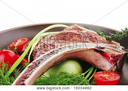 cibo di carne: manzo alla griglia di ricambio rib sul piatto scuro con timo pepe e pomodoro isolato su bianco bac