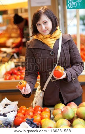 Beautiful Young Woman Selecting Date Plums At Market
