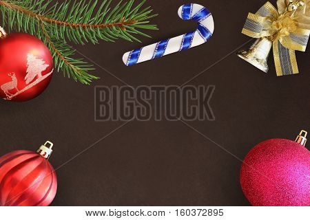 Christmas fir branch red wavy and pink ball stick bell on a dark background