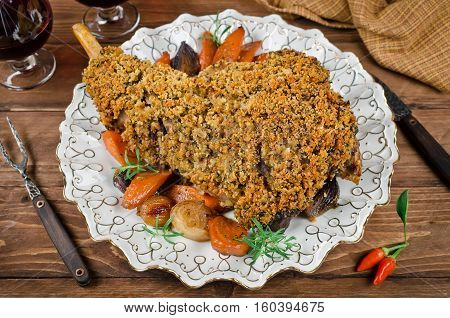 Leg of lamb baked with spicy bread crust. Roast leg of lamb with roasted vegetables in the round dish
