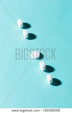 Medication Pills In A Row Against A Blue Background.