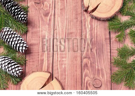 Christmas New Year composition with tangerines, cones, nuts, wicker basket and fir branches in rustic style on old wooden background, selective focus, Background new year, fir, gift, cones, orange, blue ball, red background