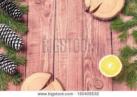 Christmas New Year composition with tangerines, cones, nuts, wicker basket and fir branches in rustic style on old wooden background, selective focus, Background new year, fir, gift, cones, orange, blue ball, red background