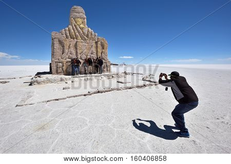 UYUNI BOLIVIA - AUGUST 28 2016: Unidentified people at Dakar Rally Monument in Salar de Uyuni (Salt Lake) near Uyuni Bolivia.