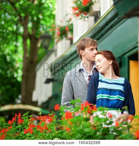 Man And Woman Together On Balconyof Their House Or Hotel With Blossoming Geranium And Nice View