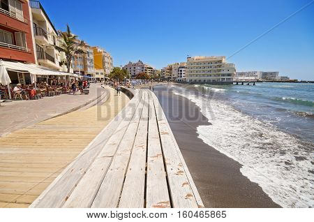TENERIFE SPAIN - JUNE 11: Scenic view of some tourist walking on a Promenade in El Medano Beach on June 11 2015 in El Medano Canary Island Tenerife Spain