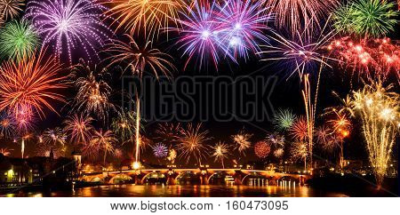Cheerful fireworks display in the city with lots of colorful bangs rising high into the night sky with black copyspace