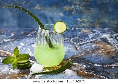 Sparkling cucumber mint gin and tonic fizz with aloe vera on marble table. Copy space. Dragon tail cocktail for fans party