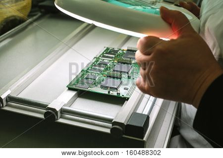 Microchip production factory. Technological process. Assembling the board. Chip. Professional. Technician. Computer expert. Manufacturing. Engineering.