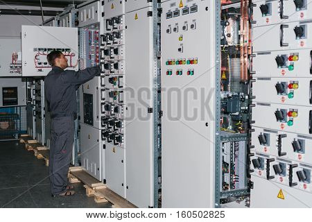Electrician near the low voltage cabinet. Uninterrupted power supply. Electricity.