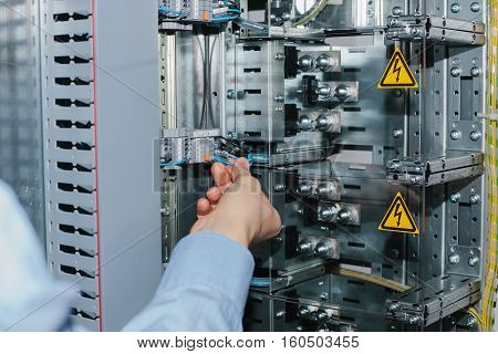 Electrician near the low voltage cabinet. Uninterrupted power supply. Electricity.