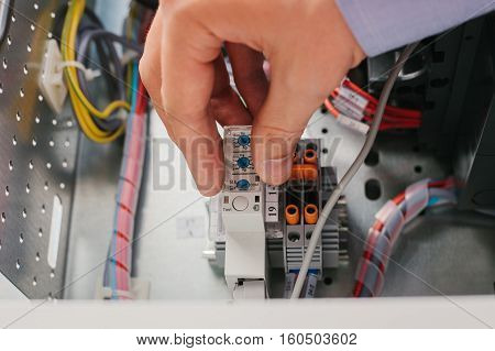 Electrician near the low voltage cabinet. Uninterrupted power supply. Electricity.