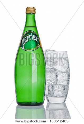LONDON UK - DECEMBER 06 2016: Bottle and glass with ice of Perrier sparkling water. Perrier is a French brand of natural bottled mineral water sold worldwide.