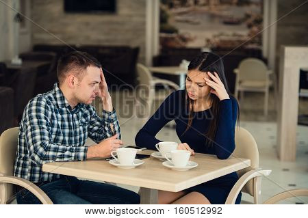 Young couple arguing in a cafe. She's had enough, boyfriend is apologizing. Relationship problems