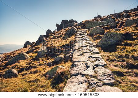 Hiking Path Uphill in Mountains. Many Rocks on the Slope.