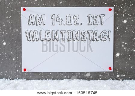Label With German Text Am 14. Februar Ist Valentinstag Means February 14th Is Valentines Day. Urban And Modern Cement Wall As Background On Snow With Snowflakes.