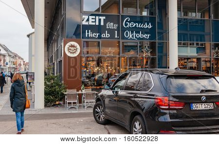 KEHL GERMANY - DEC 2 2016: Woman walking toward Peters Cafe the leading Cafe chain in Baden-Wurtemberg land
