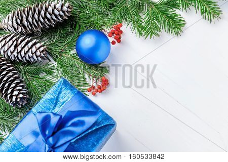 Christmas New Year composition with tangerines, cones, nuts, wicker basket and fir branches in rustic style on old wooden background, selective focus, Background new year, fir, gift, cones, orange, blue ball, red background, snow, ,
