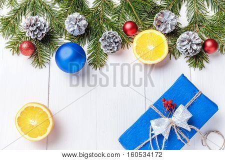 Christmas New Year composition with tangerines, cones, nuts, wicker basket and fir branches in rustic style on old wooden background, selective focus, Background new year, fir, gift, cones, orange, blue ball, red background, snow, ,