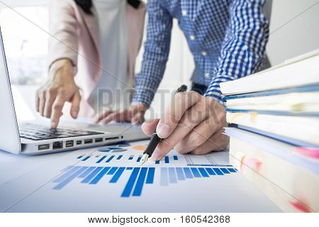 Team work process. young business managers crew working with new startup project. labtop on wood table typing keyboard texting message analyze graph plans