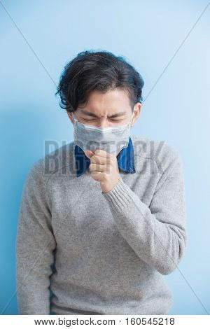 man is coughing isolated on blue background asian
