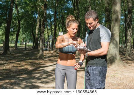 Fitness Instructor With Young Female Disscus Training Strategy